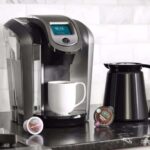 A beautiful Single Serve coffee maker brewing a cup of coffee with coffee pods nearby.